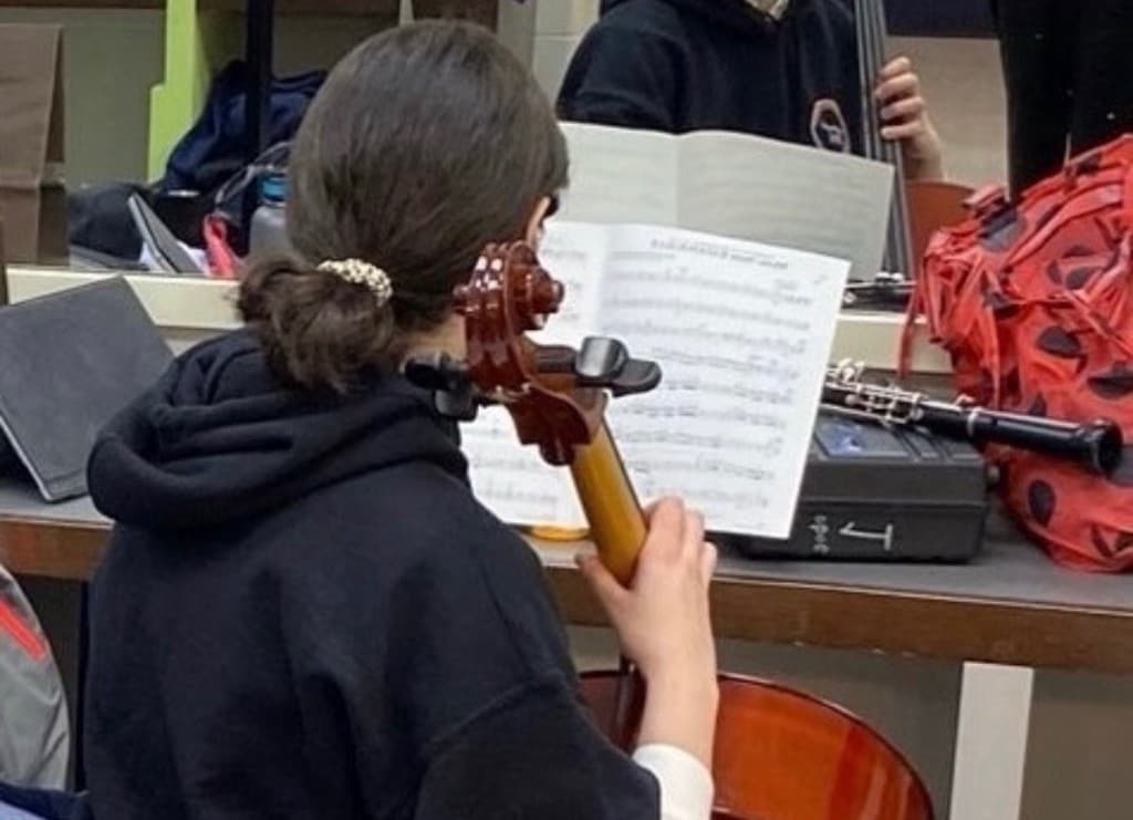 Dorsa playing cello during an orchestra rehearsal