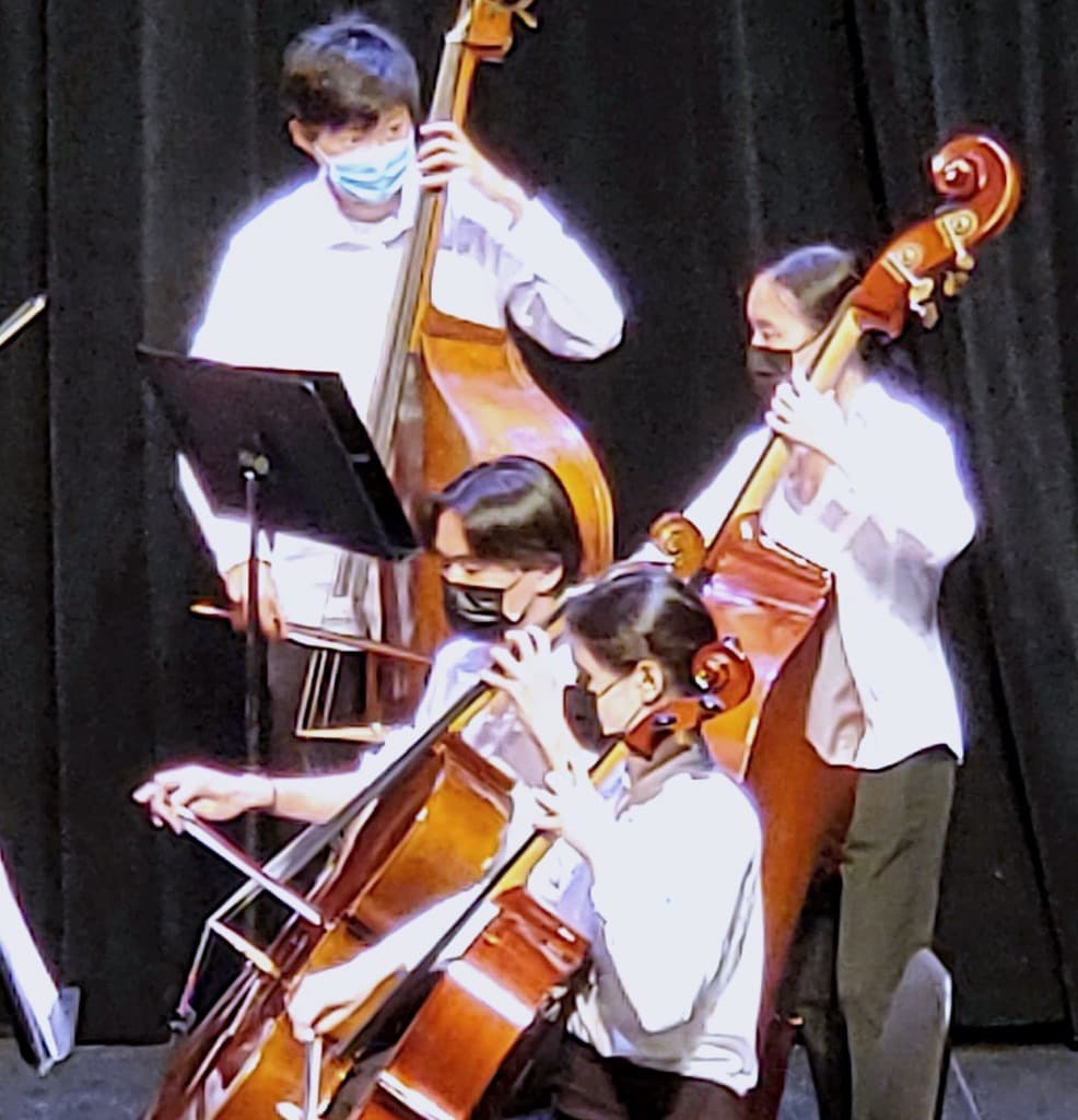 Dorsa playing cello on stage with her orchestra